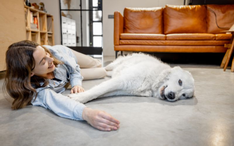 woman and her dog laying on the floor