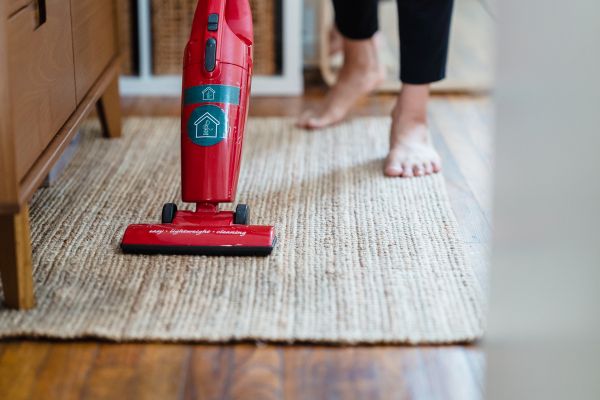vacuuming rug in bedroom